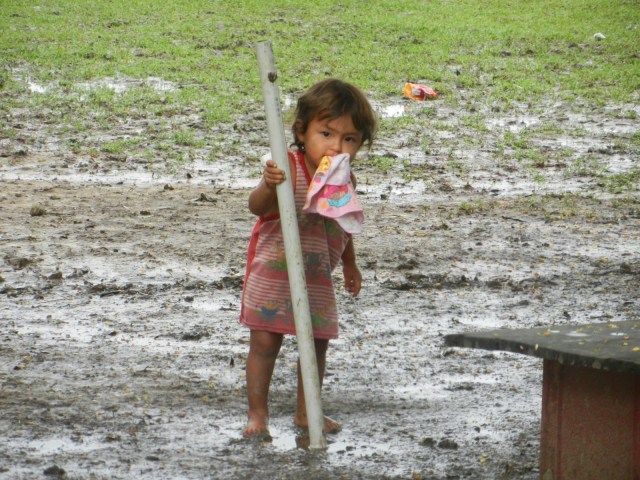 Une petite fille dans la boue, cernée de moustiques avec une chaussette dans la bouche...